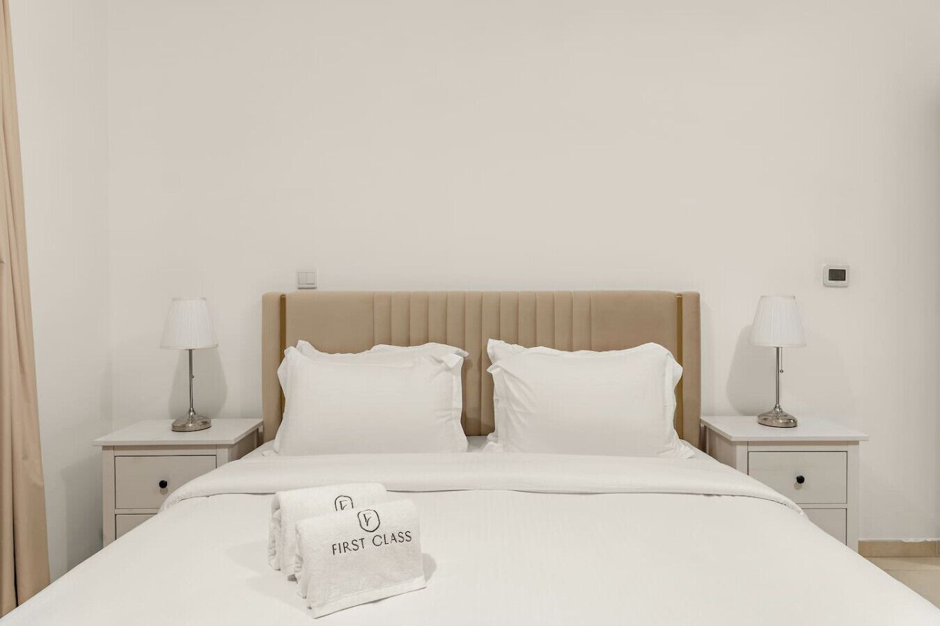 A hotel room with a bed, two bedside tables, and a nightstand.