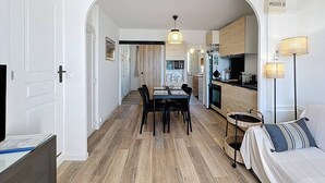 A modern apartment with a dining area, kitchen, and living space.