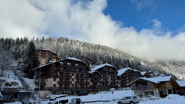 A snow-covered hotel with multiple balconies and a mountain backdrop. - 2 bedroom appt 20 mins from Morzine and rest of Portes du Soleil (Le Biot)
