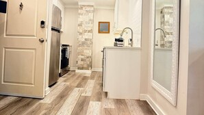 A modern kitchen with a central island, built-in appliances, and a stone accent wall.