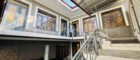 A multi-level building with a balcony, stairs, and a covered area.
