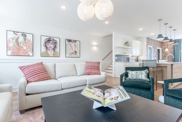 A modern living room with a sofa, armchairs, a coffee table, and artwork on the wall. - Luxe 4BR Retreat With Hot Tub Skyline Deck (Nashville)