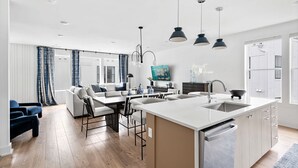 A modern kitchen with a central island, built-in appliances, and pendant lighting. - Rooftop Fire Pit Lounge Skyline DT Nash Views (Nashville)