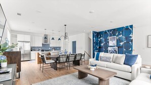 A modern living room with a sofa, coffee table, and dining area. - Rooftop Fire Pit Lounge Skyline DT Nash Views (Nashville)