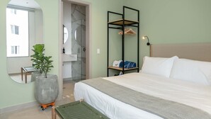 A bedroom with a bed, a large potted plant, a mirror, and a wardrobe. - w Peaceful 2BR w Beautiful Terrace in CTG (Cartagena)