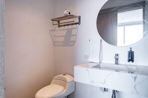 A modern bathroom with a toilet, a marble sink, a mirror, and a towel rack. - w Idyllic 3BR w Vibrant Terrace in CTG (Cartagena)