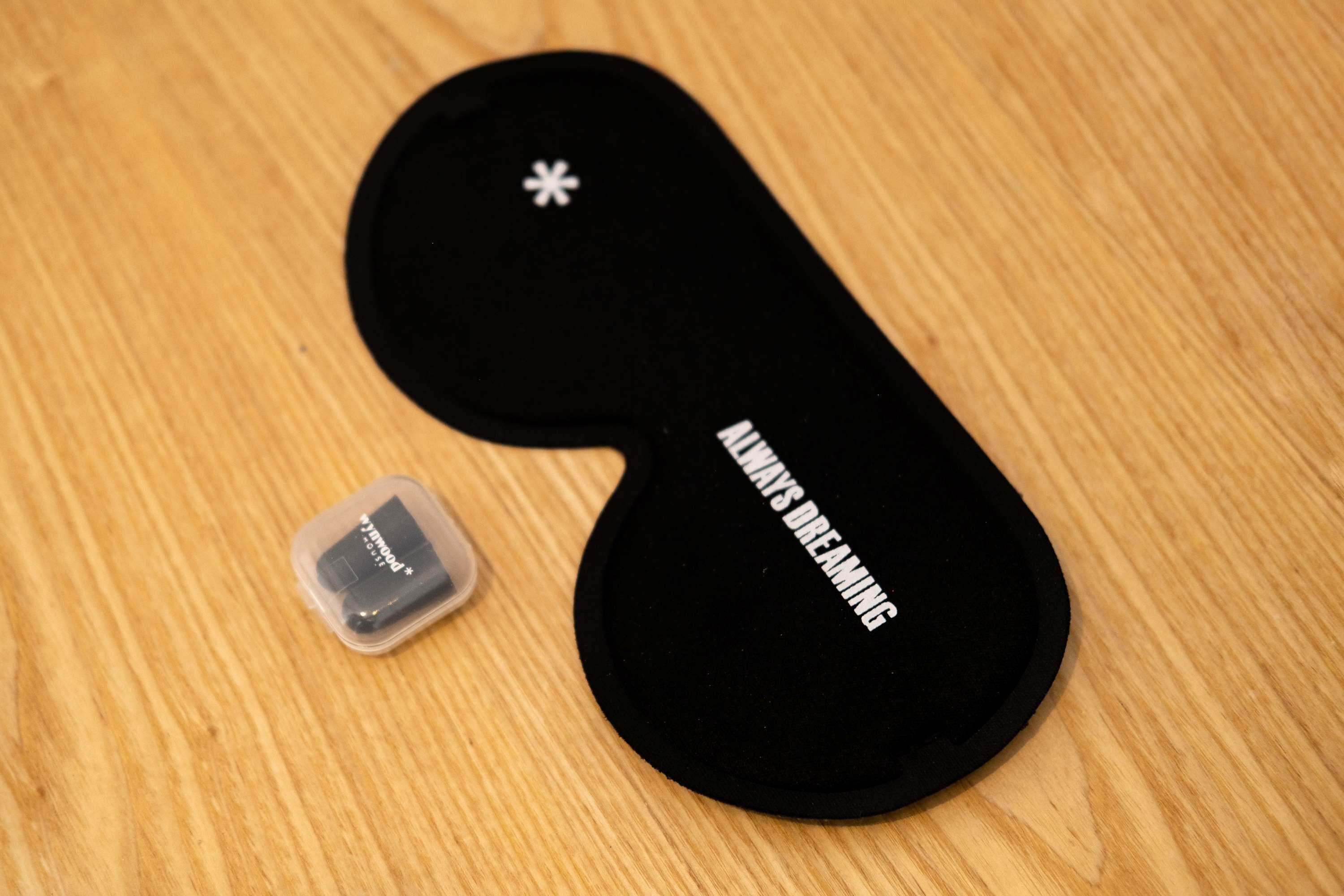 A black object with a white star and text on it, placed on a wooden surface.