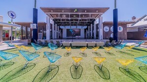 An outdoor amphitheater with a stage, seating, and colorful chairs. - Tryin' To Catch A Good Time-30A Townhome with 6-Seater Golf Cart! Sleeps 8 (Santa Rosa Beach)