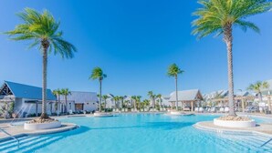 A swimming pool with palm trees, lounge chairs, and resort buildings. - Tryin' To Catch A Good Time-30A Townhome with 6-Seater Golf Cart! Sleeps 8 (Santa Rosa Beach)