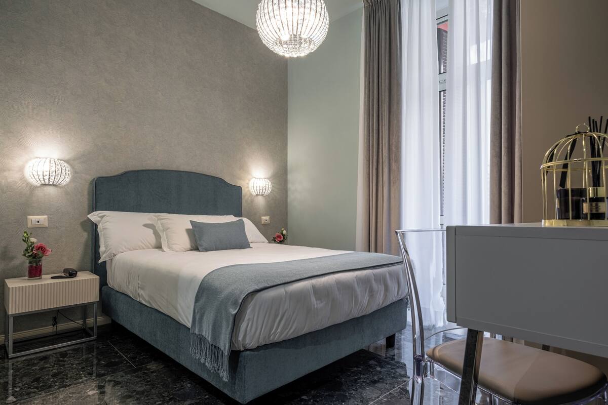 Une chambre moderne avec un grand lit, des lampes de chevet, un bureau et une chaise.