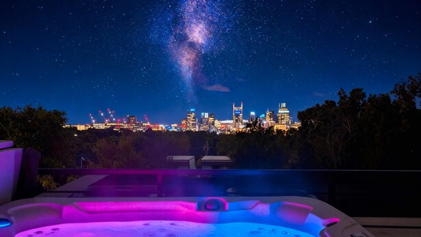A hot tub with a city skyline view at night. - Nashville Retreat With Hot Tub Private Garage (Nashville)