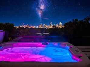 A hot tub with a city skyline view at night. - Nashville Retreat With Hot Tub Private Garage (Nashville)