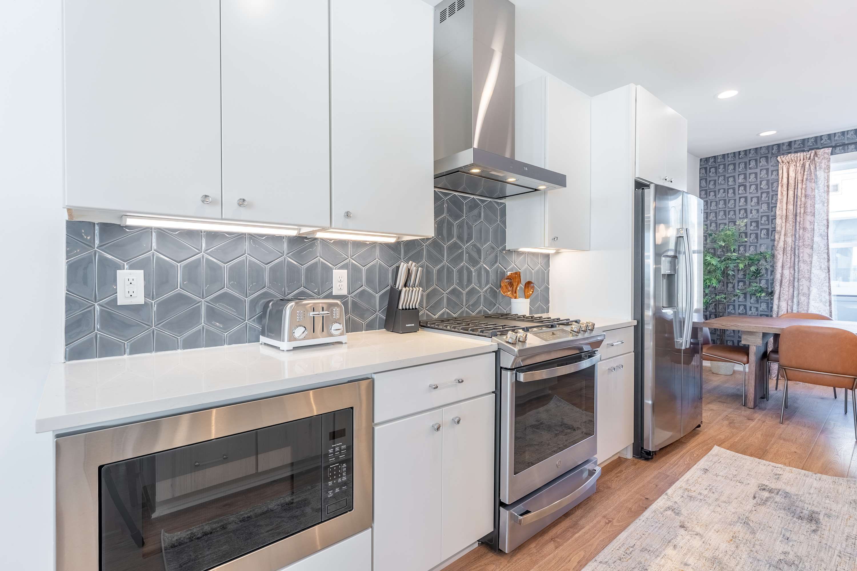 A modern kitchen with stainless steel appliances, a gas stove, and a built-in oven.
