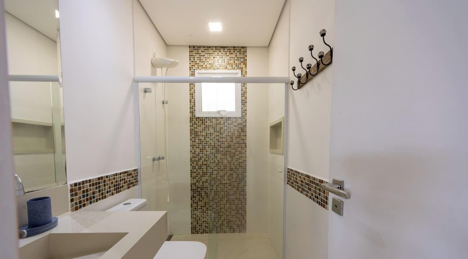 A modern bathroom with a shower, a toilet, and a sink.