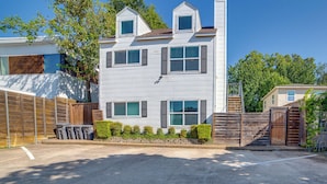 A two-story house with a central chimney, multiple windows, and a fenced yard. - Walk to Restaurants & Bars: Modern Dallas Retreat (Dallas)