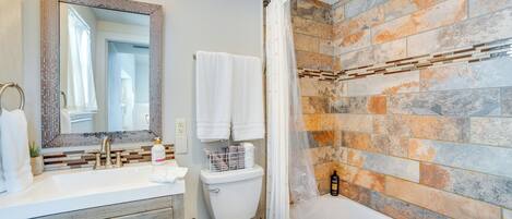 A bathroom with a white sink, a toilet, and a bathtub.