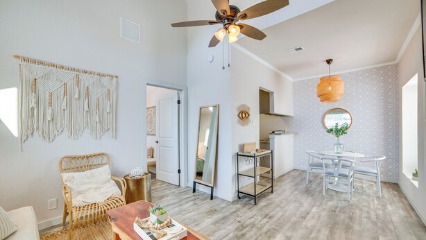 A spacious living room with a ceiling fan, a dining area with a round table and chairs, and a large mirror on the wall. - Walk to Restaurants & Bars: Modern Dallas Retreat (Dallas)