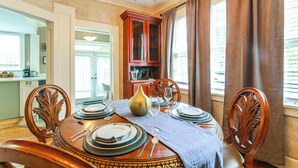 A dining room with a wooden table set for four, surrounded by chairs. - Fire Pit & Yard! Charming Home, 5 Mi to Fedexforum (Memphis)