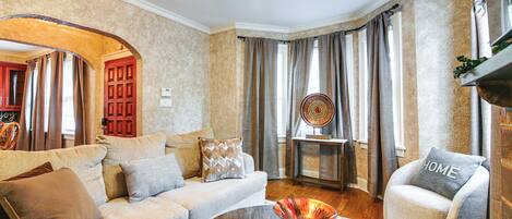 A living room with a sofa, armchair, coffee table, and a decorative bowl.