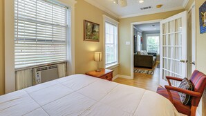 A bedroom with a large bed, a ceiling fan, and a view into the living area. - Walk to Shops & Dining: Houston Heights Home! (Houston)