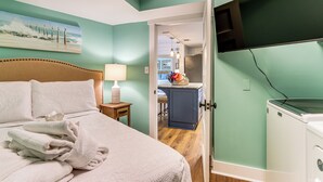Un dormitorio con una cama, una mesita de noche, una lámpara y un cuadro en la pared.