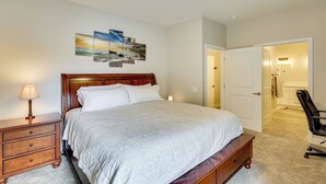 Une chambre à coucher avec un grand lit, une table de chevet, une lampe et une chaise.