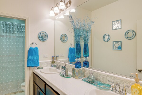 A bathroom with two sinks, a mirror, and decorative blue glass vases. - 4 Mi to Csub Campus: Spacious Home w/ Yard (Bakersfield)