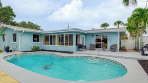 Una casa con piscina, patio coperto e garage.