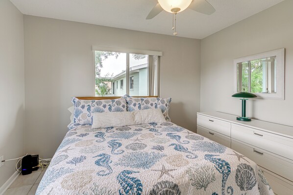 Un dormitorio con cama, cómoda, espejo y ventana.