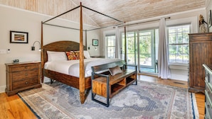 A four-poster bed with a wooden frame, a bench with storage, a nightstand, and a dresser. - Mtn Views, Deck, Porches & Patio: Asheville Escape (Asheville)