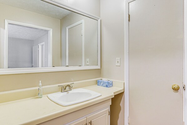 A bathroom with a white sink, a mirror, and a door. - 5 Mi to Fort Bragg: Family Gem Near Parks & Trails (Fayetteville)
