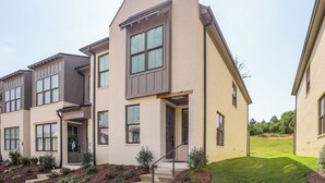 A modern two-story residential building with a flat roof, large windows, and a well-maintained lawn. - King Suites for Every Couple, Kickoff 3 Mi (Oxford)