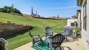 A patio area with outdoor seating, a green turf, and a view of a construction site. - King Suites for Every Couple, Kickoff 3 Mi (Oxford)
