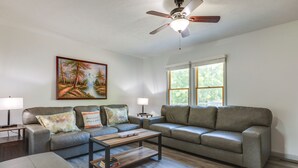 Ein Wohnzimmer mit einer Couch, einem Couchtisch und einem Gemälde an der Wand.