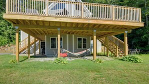 A two-story house with a wooden deck, a hammock, and a staircase. - Walk to Lake Winnisquam Access: Cozy Retreat (Sanbornton)