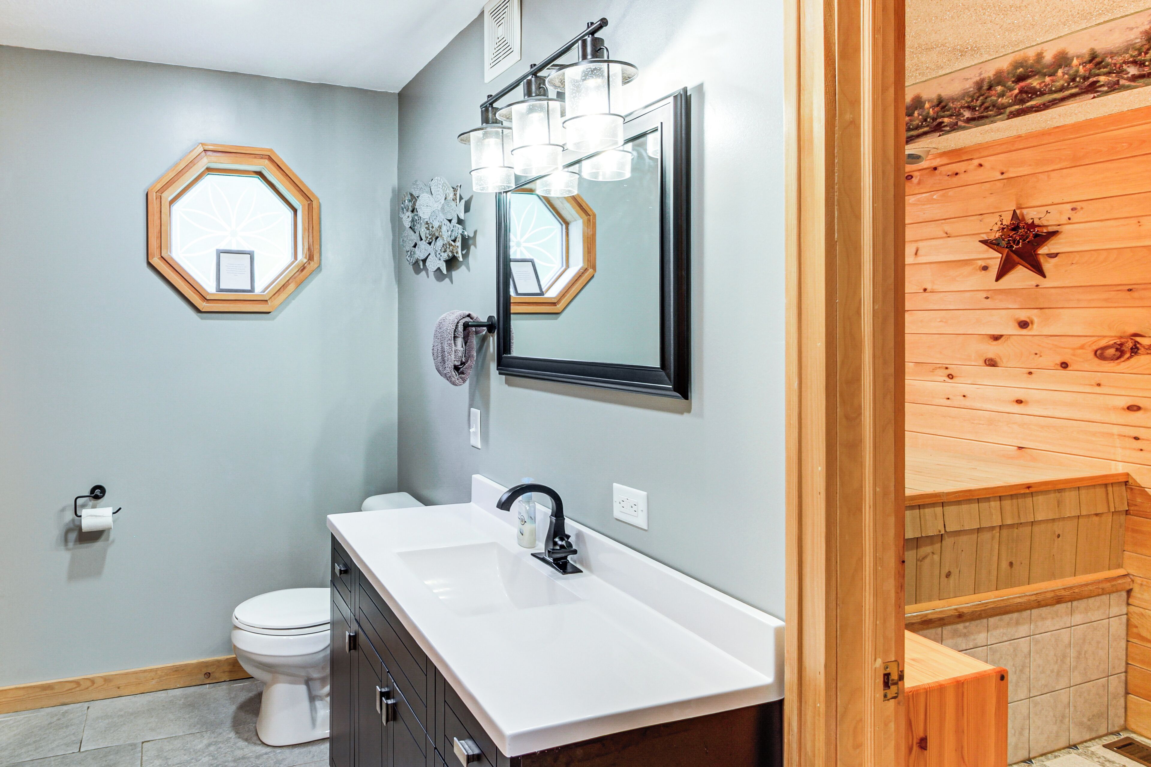 A bathroom with a white sink, a mirror, and a toilet.