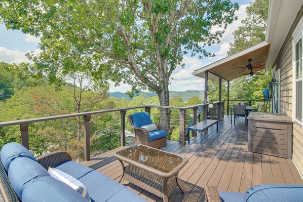 A deck with outdoor furniture, a ceiling fan, and a view of the surrounding landscape. - Lake View Home in Silver Point: Walk to Marina (Silver Point)