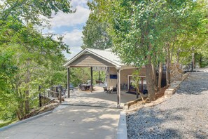 An outdoor patio area with a covered seating area, tables, and a stone wall. - Lake View Home in Silver Point: Walk to Marina (Silver Point)
