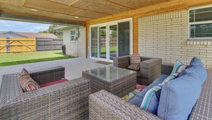 A covered patio area with wicker furniture, a glass-top table, and a view of the backyard. - Fenced Yard: Home < 1 Mi to Mayor Pablo Peña Park (Weslaco)