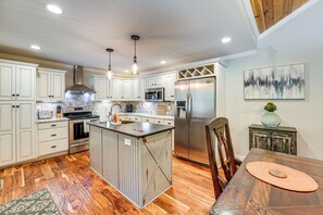 A modern kitchen with white cabinets, stainless steel appliances, and a wooden floor. - Peaceful Home w/ Porch & Yard, 5 Mi to Rome! (Rome)