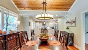 A dining room with a wooden table, chairs, a chandelier, and a fruit centerpiece. - Peaceful Home w/ Porch & Yard, 5 Mi to Rome! (Rome)