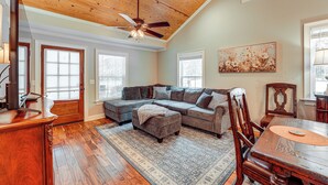 A spacious living room with a wooden ceiling, a sectional sofa, a dining table with chairs, and a large window. - Peaceful Home w/ Porch & Yard, 5 Mi to Rome! (Rome)