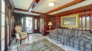 A room with a large sofa, a chair, a glass coffee table, and a painting on the wall. - Near Lake Erie, Harbor & Parks: Conneaut Getaway! (Conneaut)