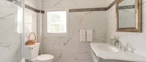 Een badkamer met toilet, wastafel en douche.
