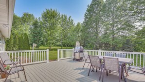 A deck with a grill, chairs, and a table. - Fish, Hike & Golf: Leisurely Navarre Home w/ Yard! (Navarre)