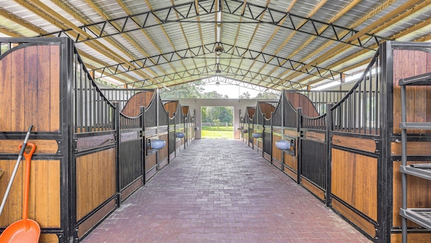 A stable with wooden stalls and a brick floor. - 16 Mi to Wec: Horse-friendly Home on 5 Acres! (Morriston)