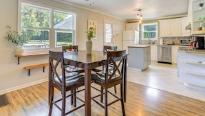 A kitchen with wooden flooring, white cabinets, a dining table with chairs, and a ceiling fan. - 16 Mi to Wec: Horse-friendly Home on 5 Acres! (Morriston)