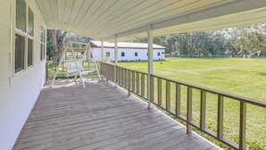 A wooden deck with a railing, a ladder, and a white building in the background. - 16 Mi to Wec: Horse-friendly Home on 5 Acres! (Morriston)