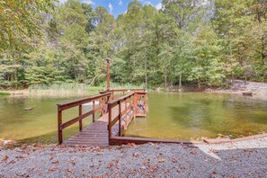 A wooden dock extending into a pond surrounded by trees. - Cottage By the Pond: Serene Northeast Ohio Retreat (Paris)