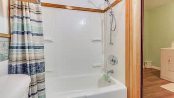 A bathroom with a bathtub, shower, and toilet.